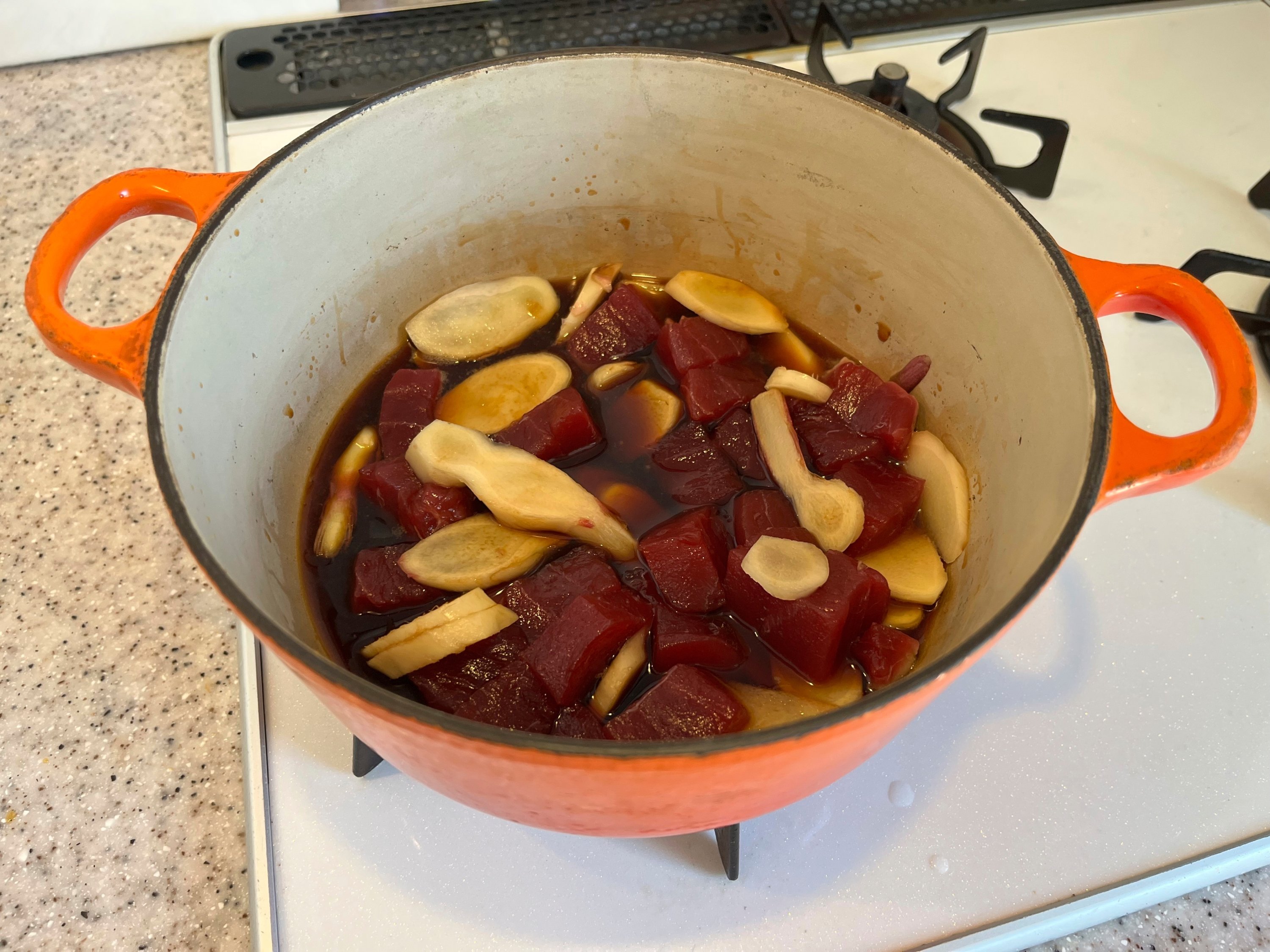 Chopped tuna and sliced ginger simmer in a sauce consisting of soy sauce, mirin, sake, sugar and salt to make tsukudani, a Japanese preserved food on Monday, June 30, 2025. (AP Photo)