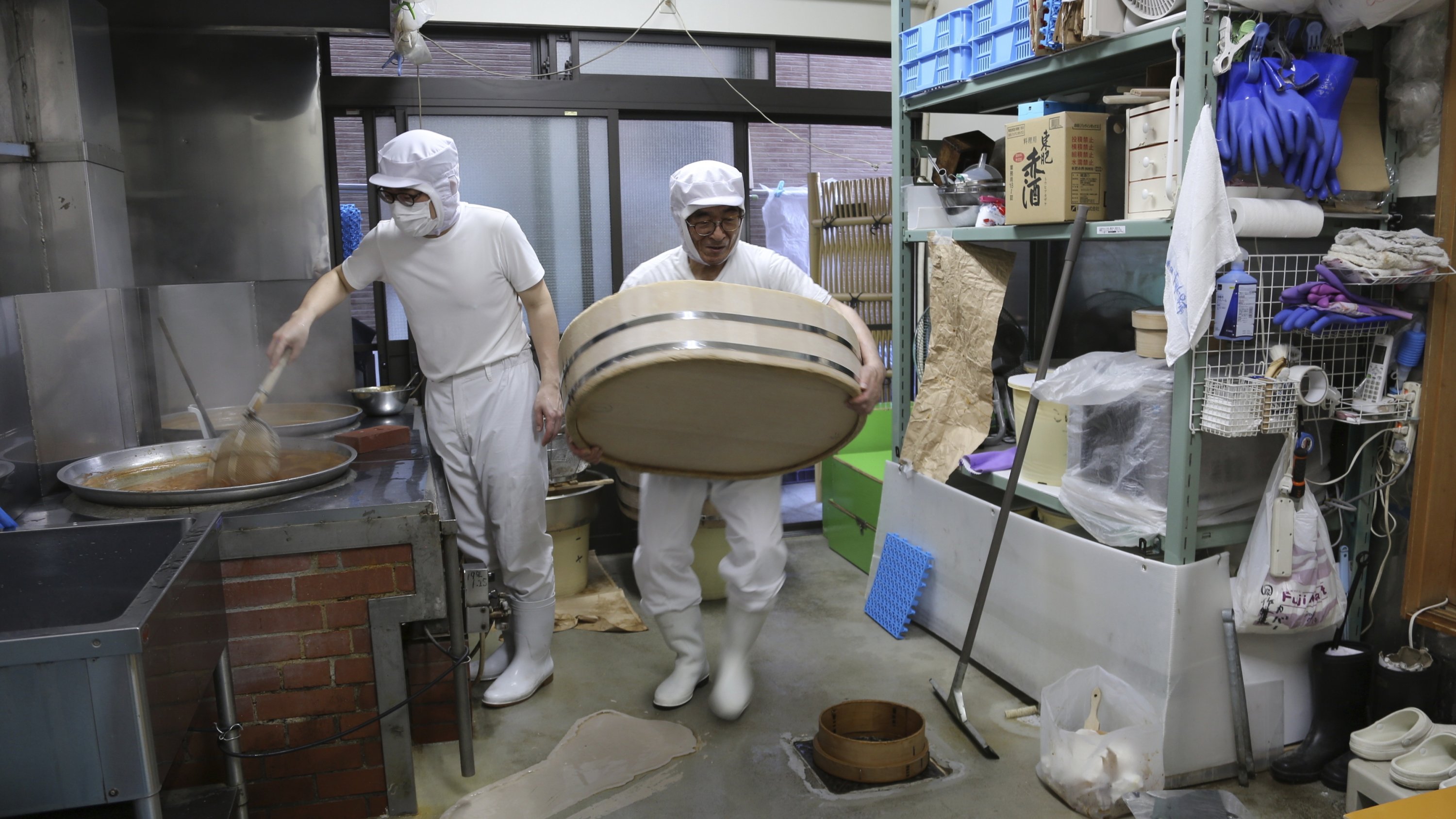 Nobuo Kobayashi (R) and his son Yoshihiro Kobayashi prepare a traditional Japanese dish called tsukudani, at their store in the Tsukuda area of Tokyo, Japan, June 18, 2025. (AP Photo)