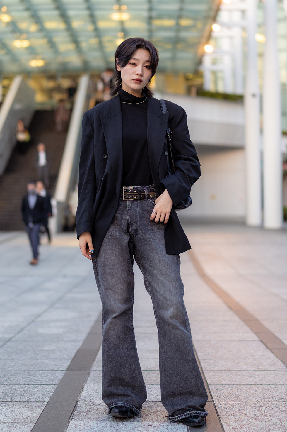 full length portrait of young female freelance worker standing in city at sunset time