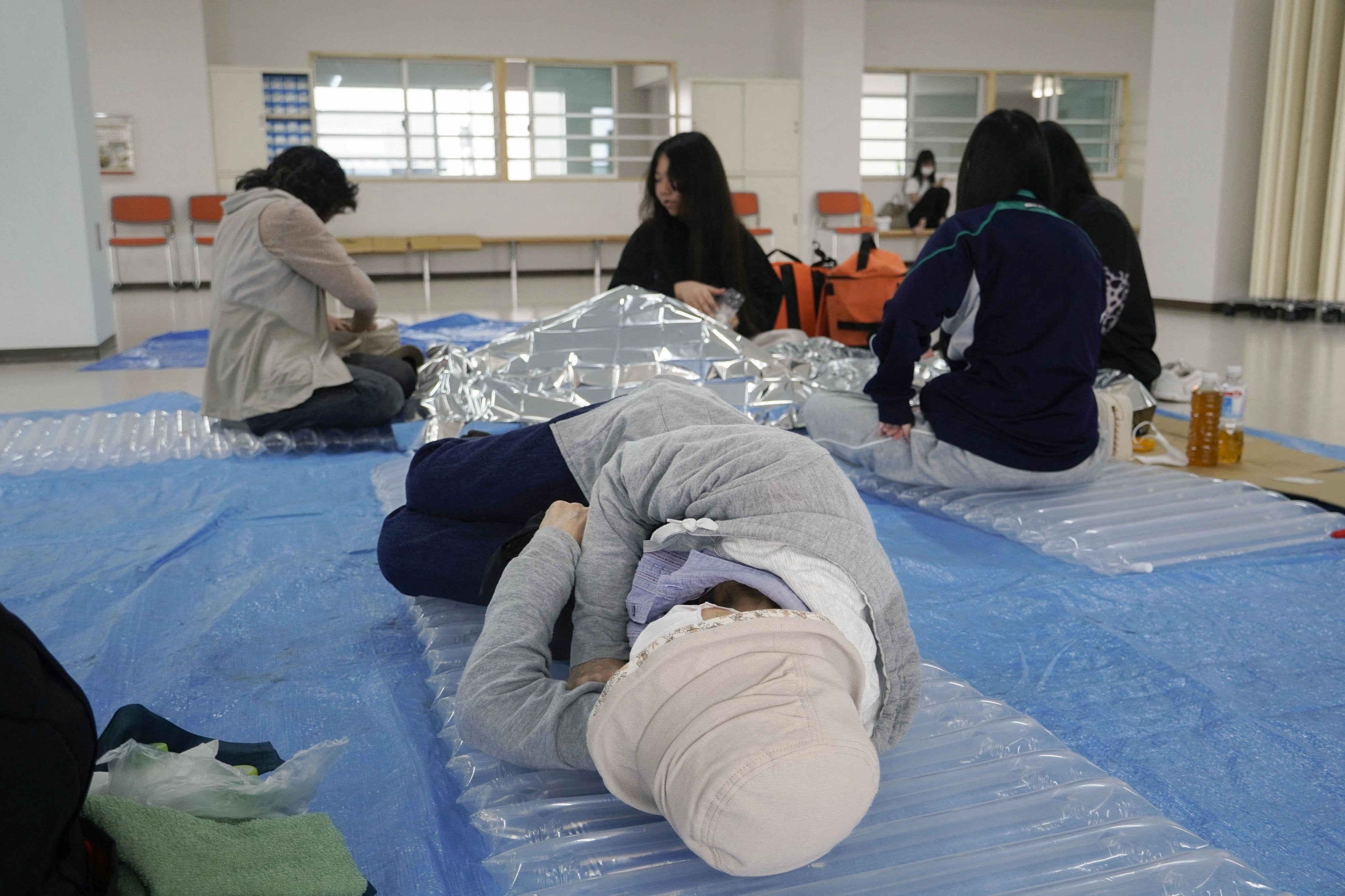 A woman lies down at an evacuation tower in Kushiro, Hokkaido, northern Japan