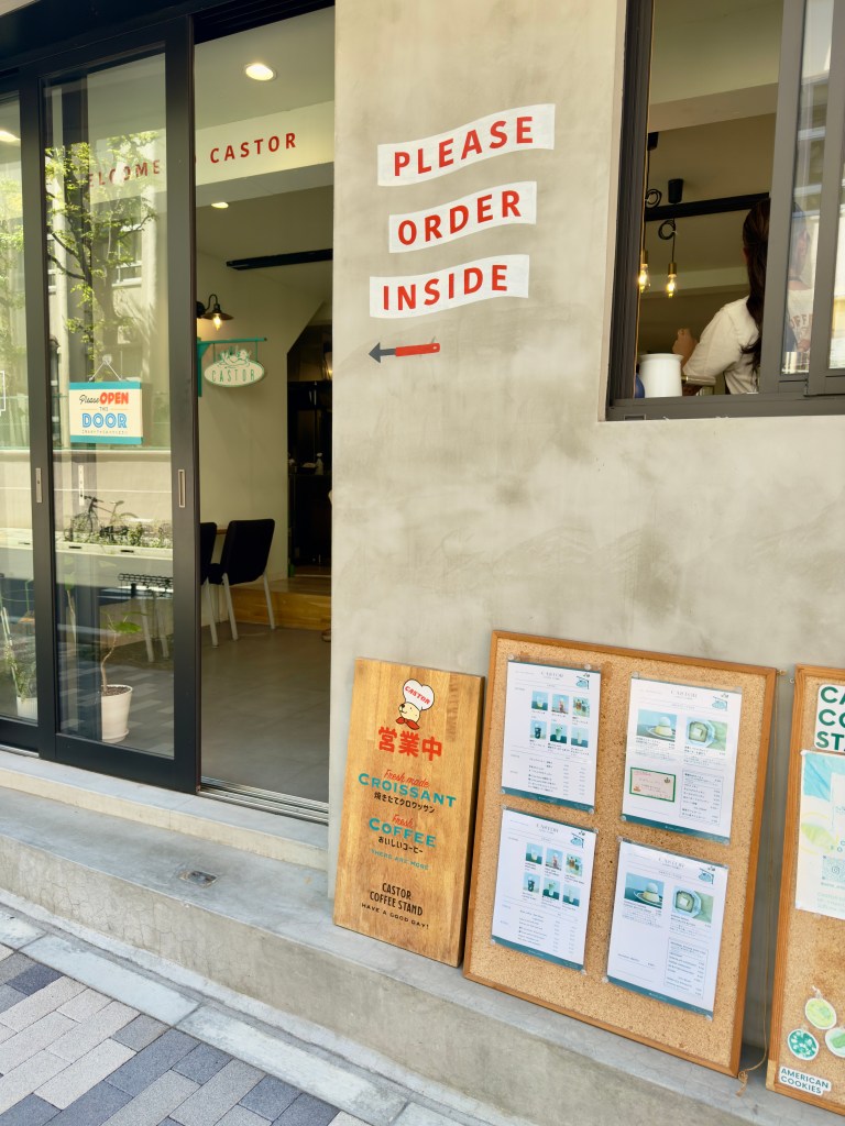 An exterior shot of Castor, a cement building with a hand painted sign that says "Please Order Inside."