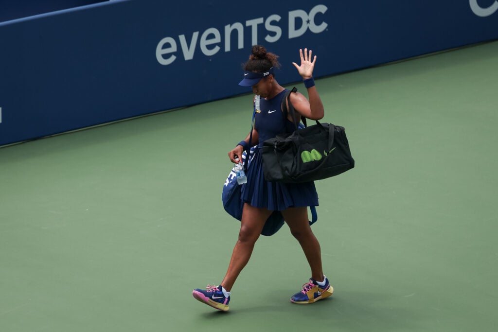 Naomi Osaka waves to the crowd as she leaves the court following a defeat to Emma Raducanu at the Mubadala Citi DC Open 2025