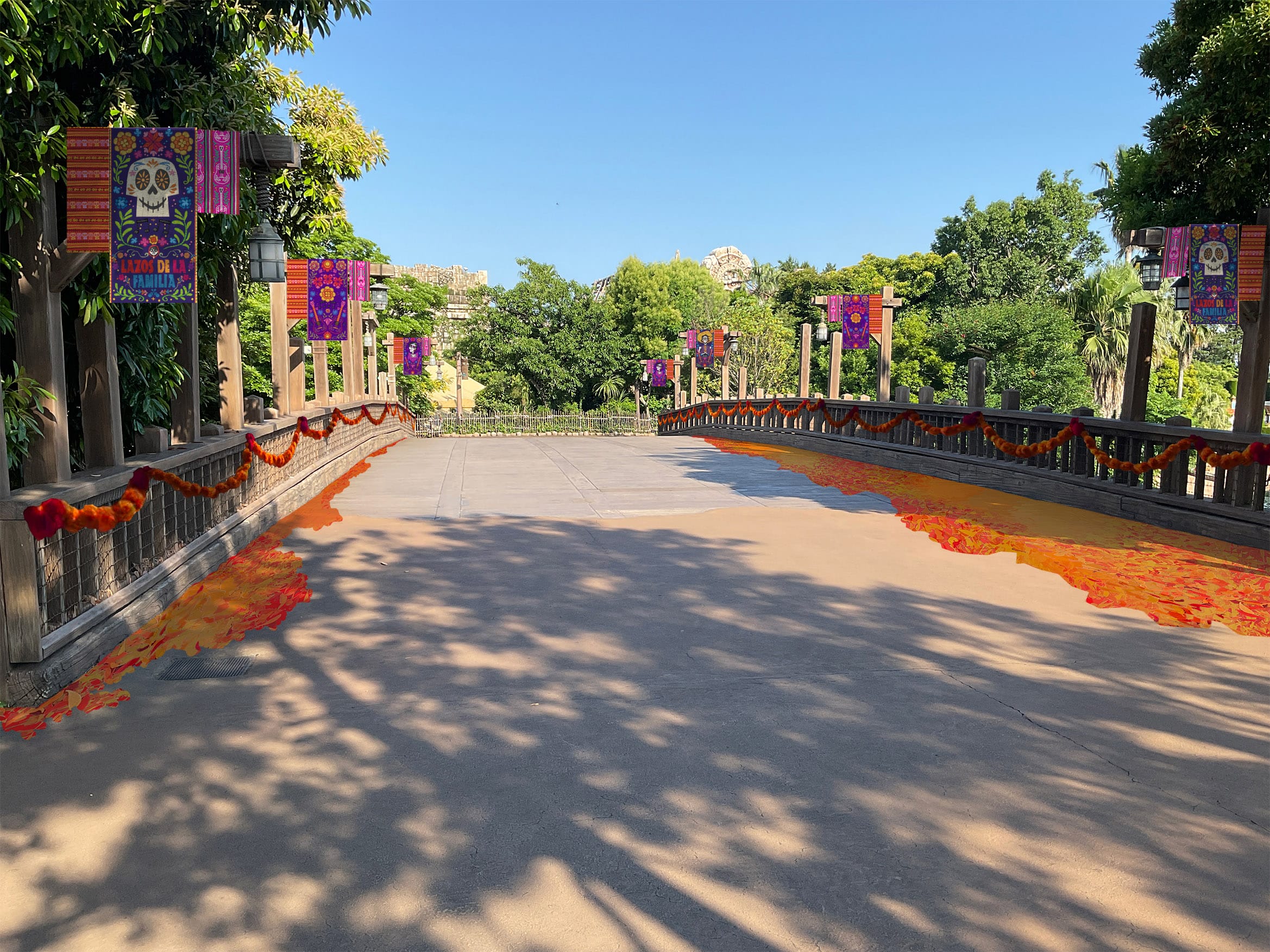 A decorated pathway with orange marigold petals and Día de los Muertos banners at Tokyo Disneyland on a sunny day.