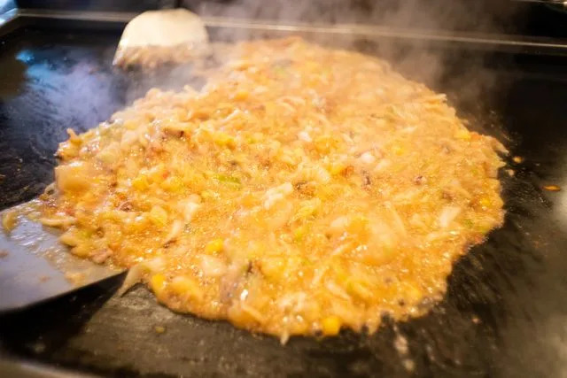 Kayoko Hayashi/Getty Images Monjayaki being cooked on a griddle.