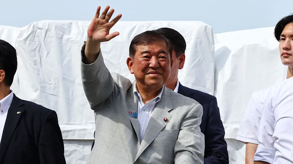 Japan's Prime Minister Shigeru Ishiba, who is also the leader of the ruling Liberal Democratic Party (LDP), waves to voters from atop an election campaign van during the LDP's election campaign tour for the July 20, 2025 Upper House election, in Yokohama, south of Tokyo, Japan July 18, 2025. He is wearing a light grey suit with no tie, and has a slight smile on his face. 