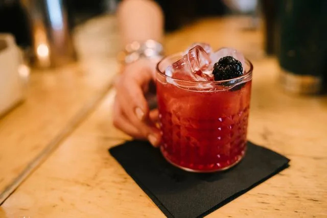 Cavan Images/Getty Images A bartender passing a cocktail.