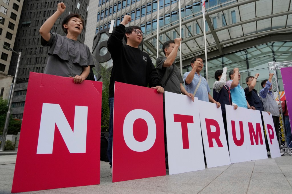 Protestors hold signs spelling out "NO TRUMP".