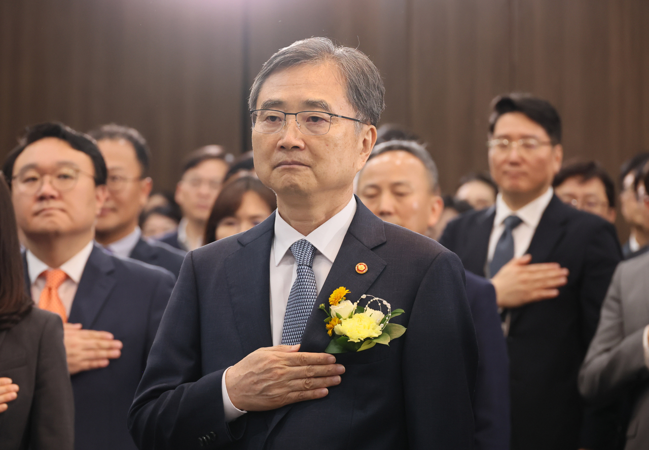 Foreign Minister Cho Hyun (center) salutes to the national flag on his first day in office at the Government Complex Seoul on July 21. (Yonhap)