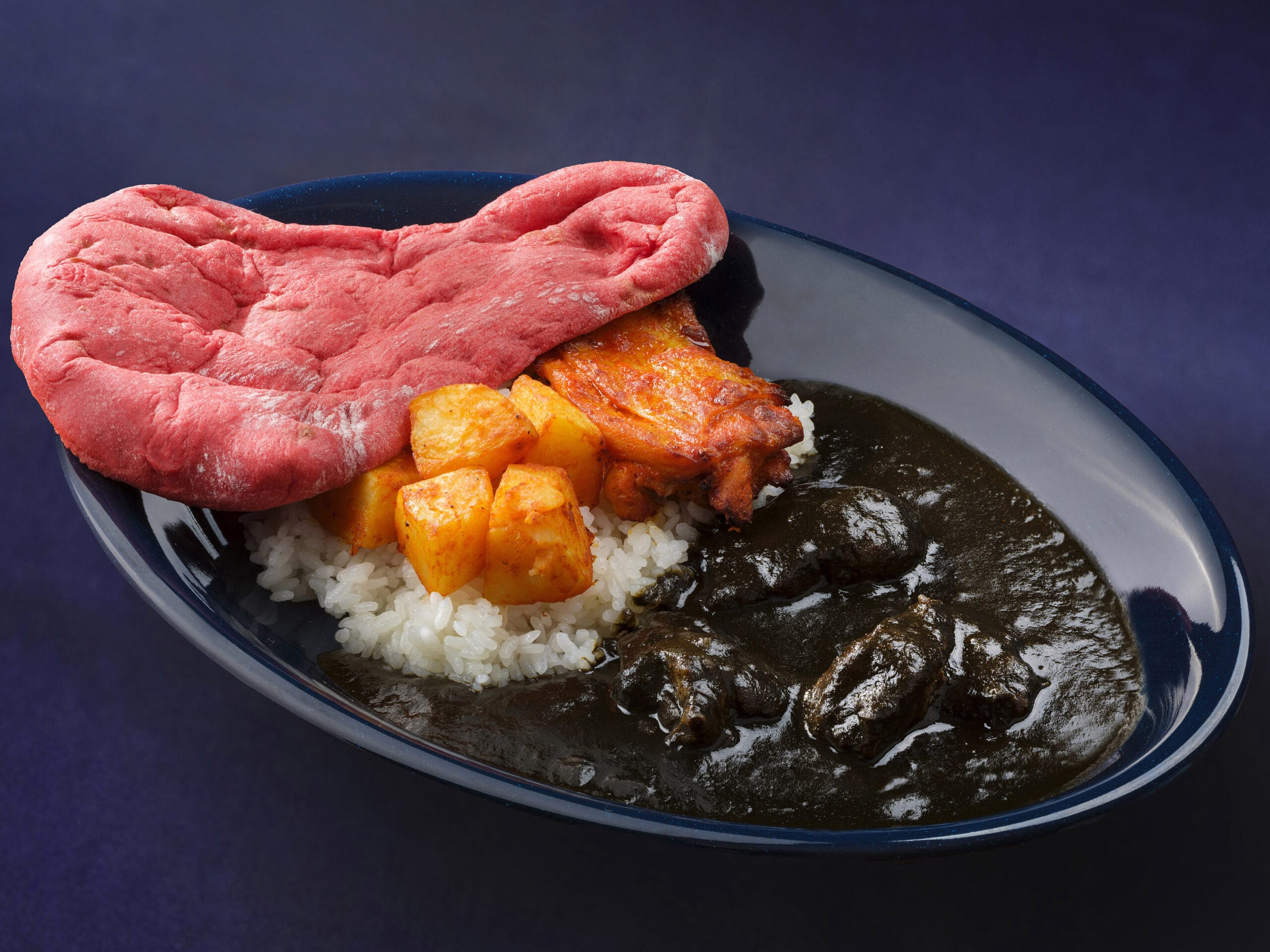A plate with white rice, black curry, potatoes, chicken, and bright pink naan inspired by Halloween at Tokyo Disney Resort.