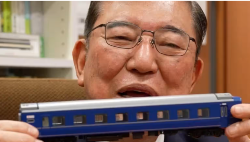 Shigeru Ishiba holding a model of the Izumo sleeper train.