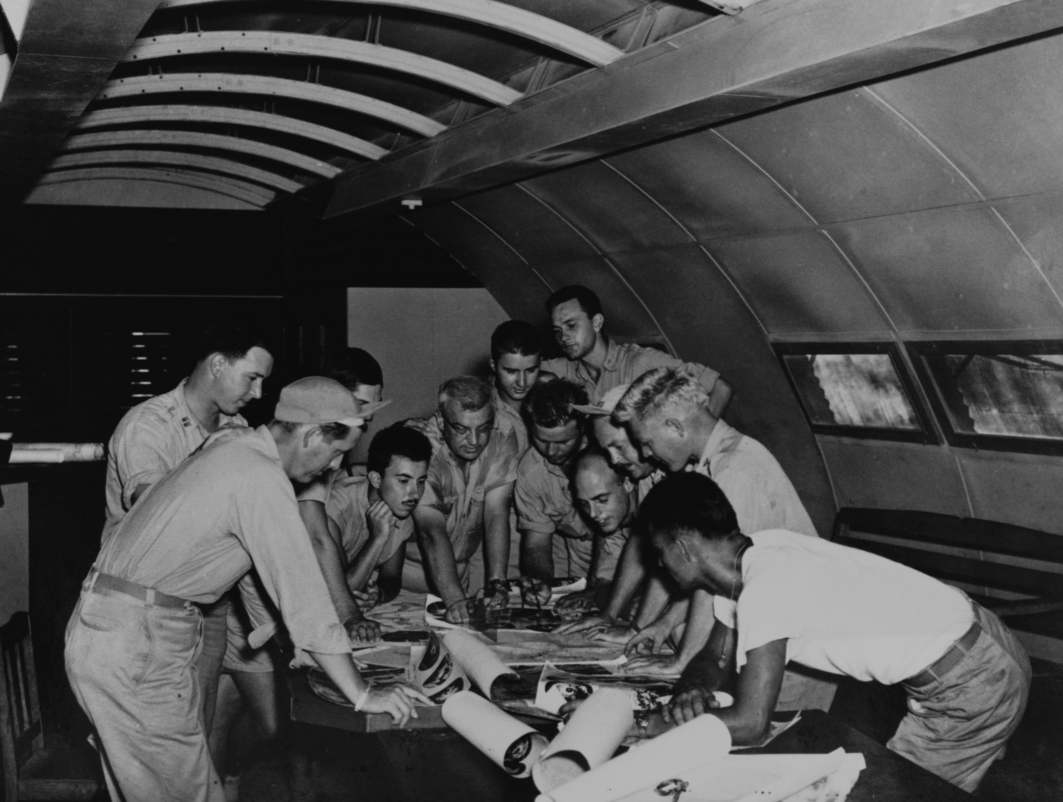 The flight crews of two planes go over plans for the dropping of the first atomic bombs
