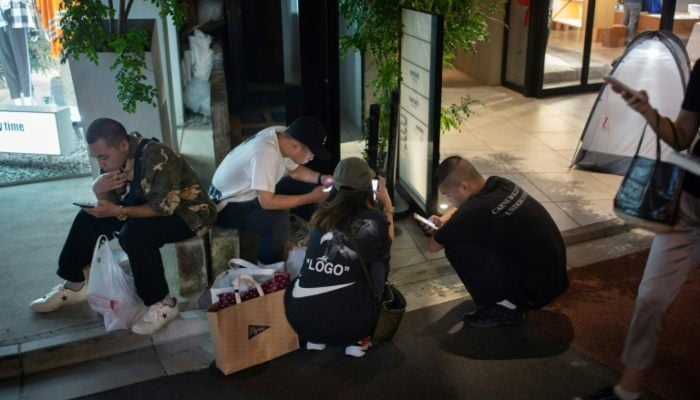 People using their smartphones in Japan. — AFP