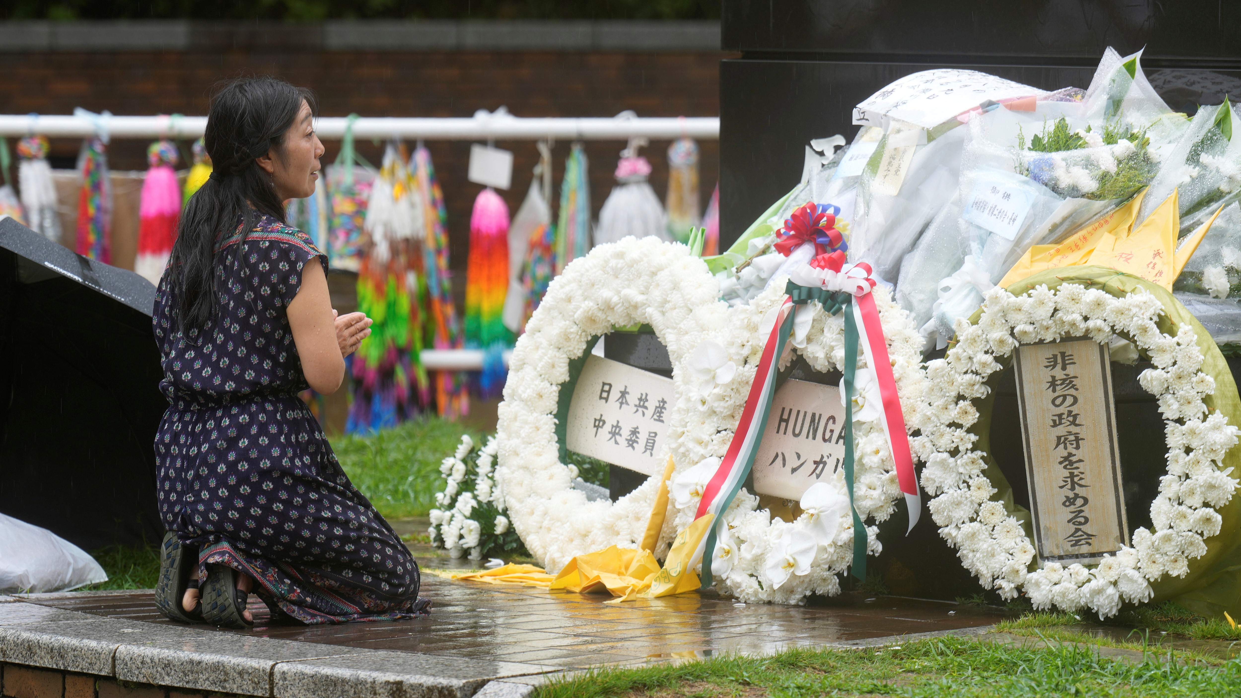 A woman offers prayer at the Atomic Bomb Hypocenter Park as Japan commemorates the 80 years since an atomic bomb was dropped on Nagasaki, Saturday, Aug. 9, 2025.