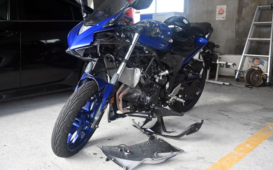A blue motorcycle with some pieces broken off after a crash.