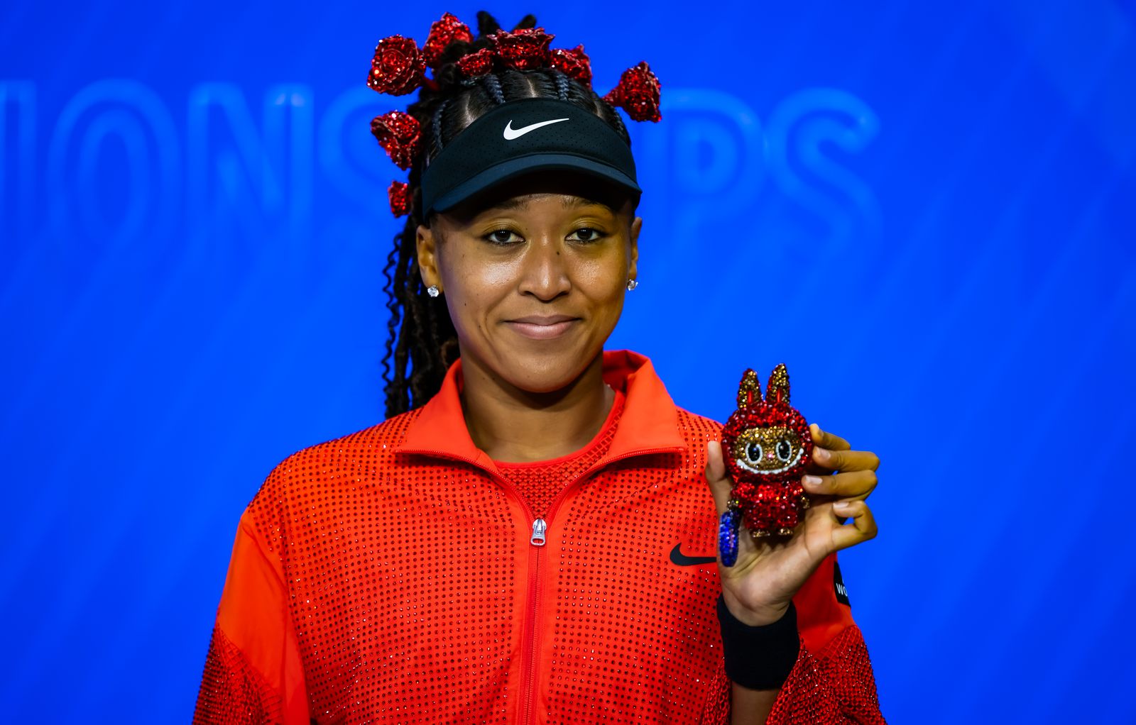 Naomi Osaka of Japan poses for a photo with her Labubu after defeating Greet Minnen of Belgium in the first round on Day...