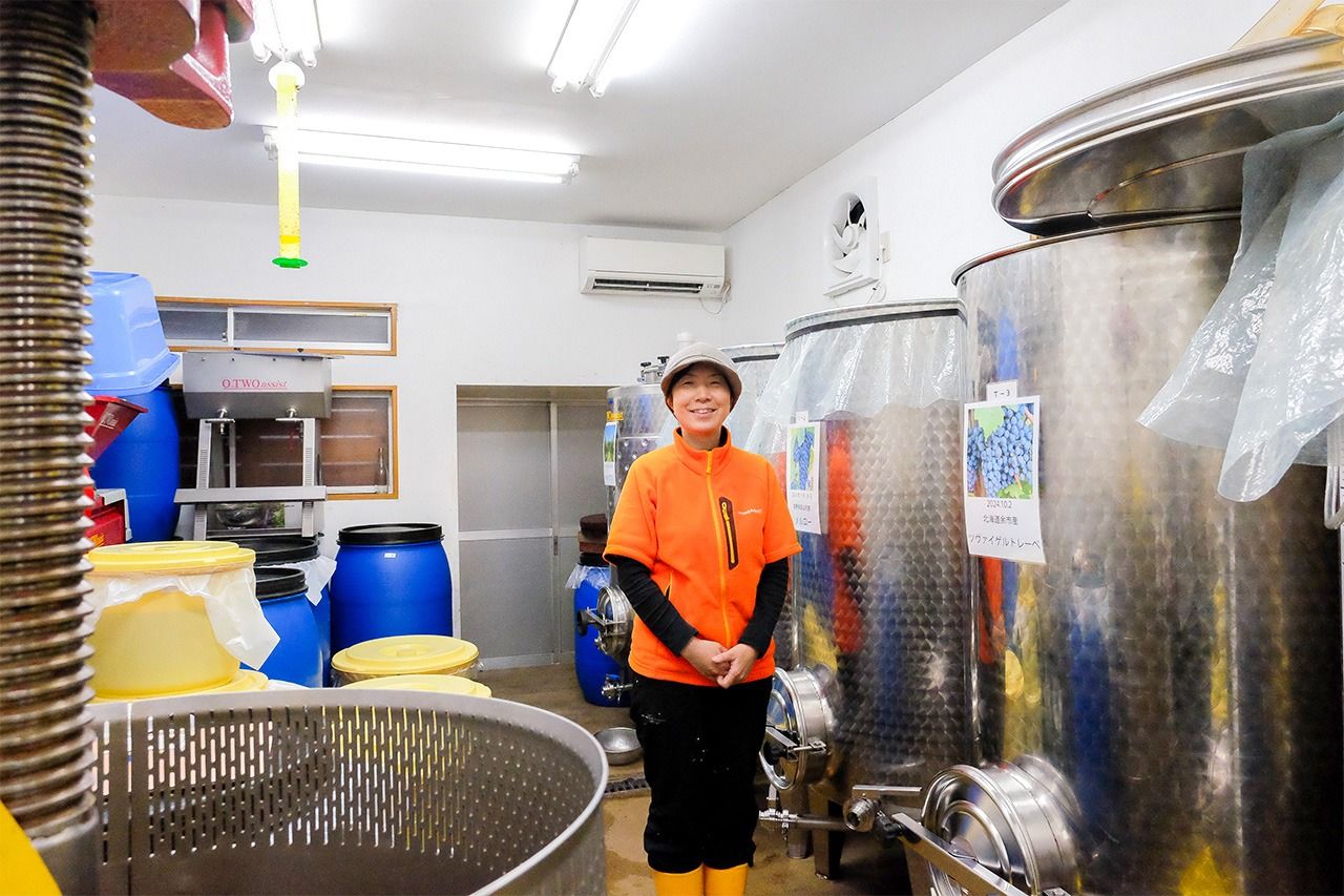 Echigoya Miwa smiles as she shows off the five fermentation tanks going full steam at Tokyo Winery. (© Kosugi Satoko)