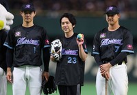 Kazunari Ninomiya, center, stands alongside Chiba Lotte Marines players Kyota Fujiwara, left, and Yudai Fujioka, after throwing the ceremonial first pitch at Tokyo Dome on July 31, 2025. (Mainichi/Kenji Ikai)