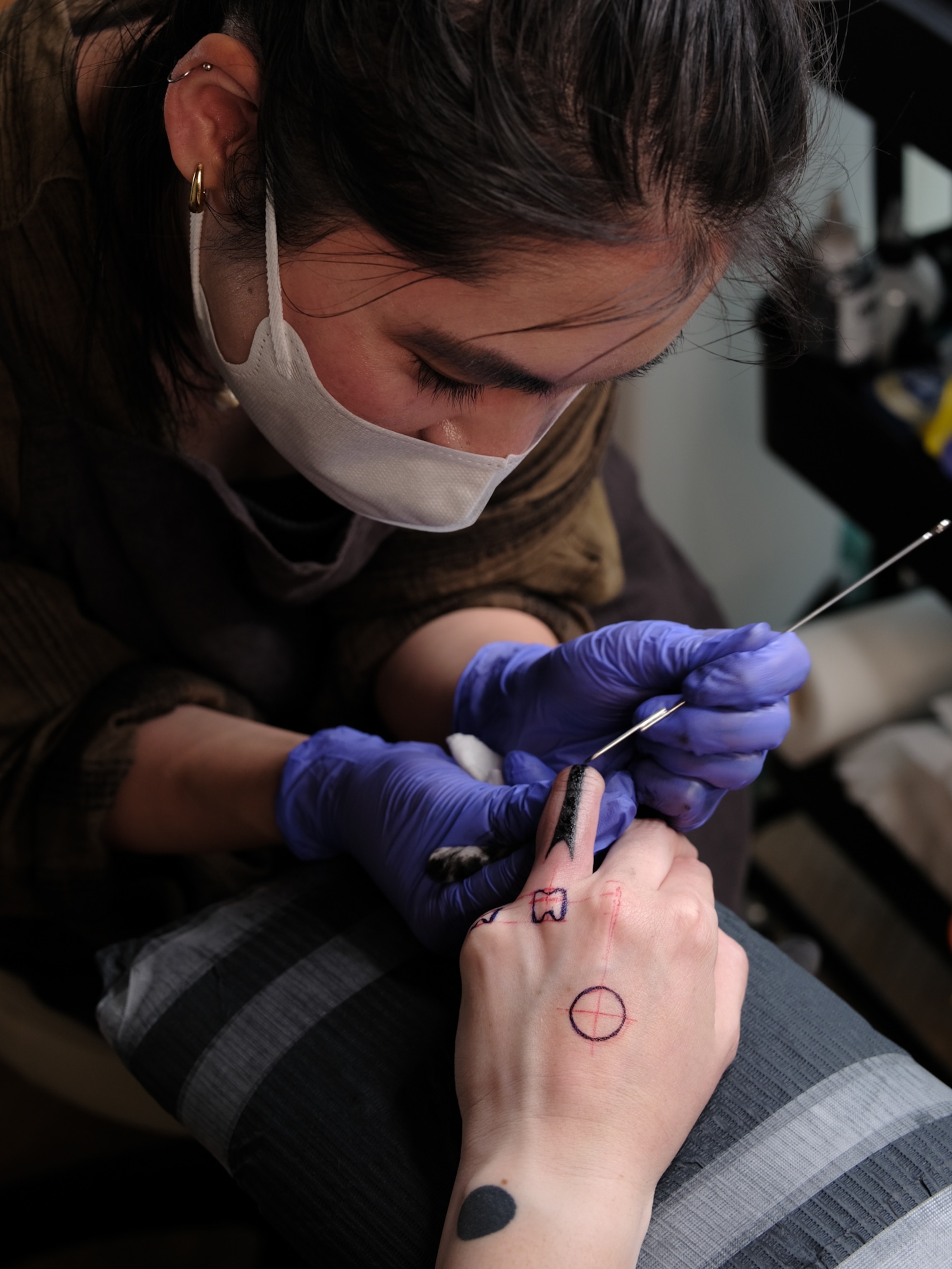 Moeko Heshiki at work in her studio performing traditional hand-poked Hajichi tattooing.