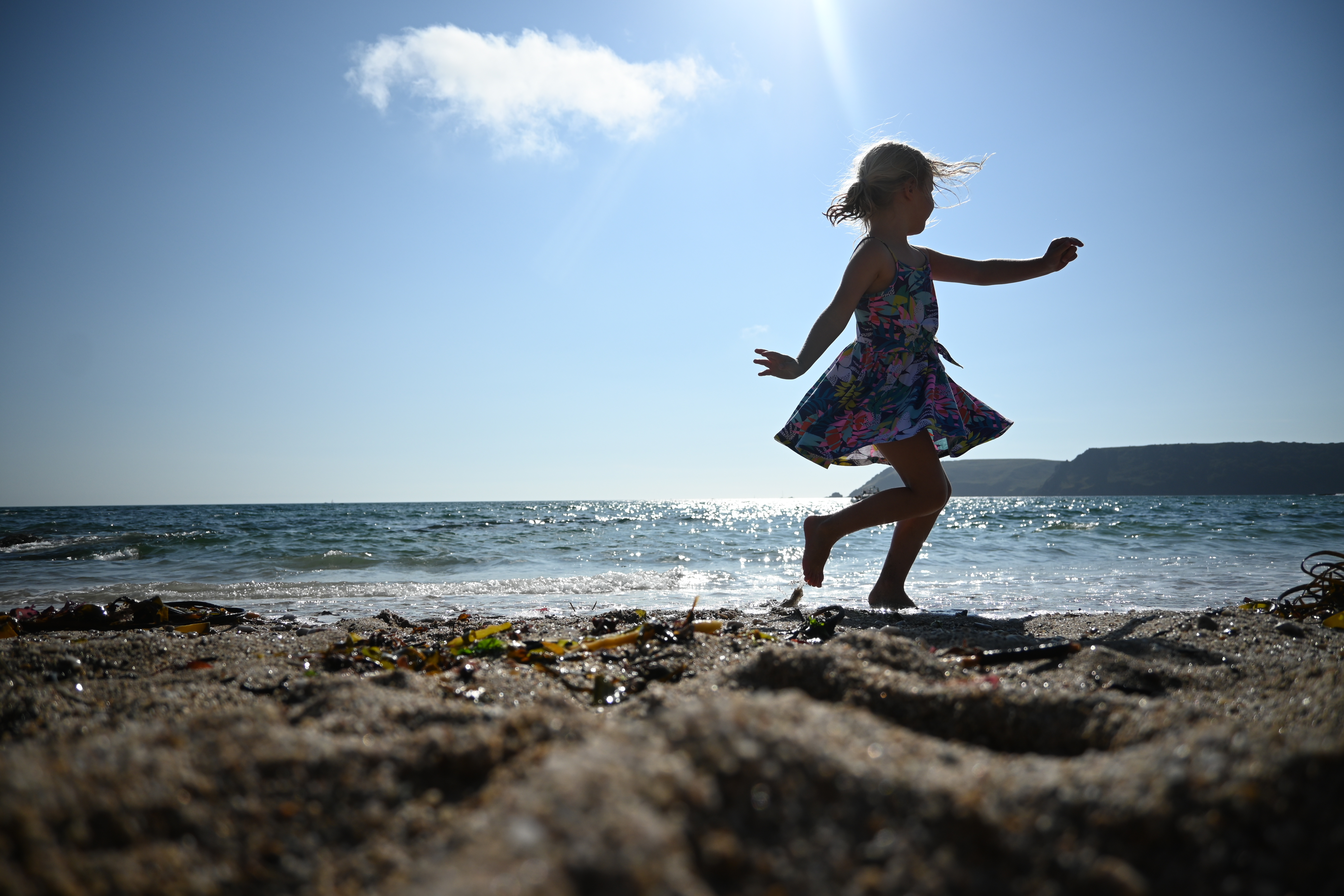 Silhouette of a girl running across the beach