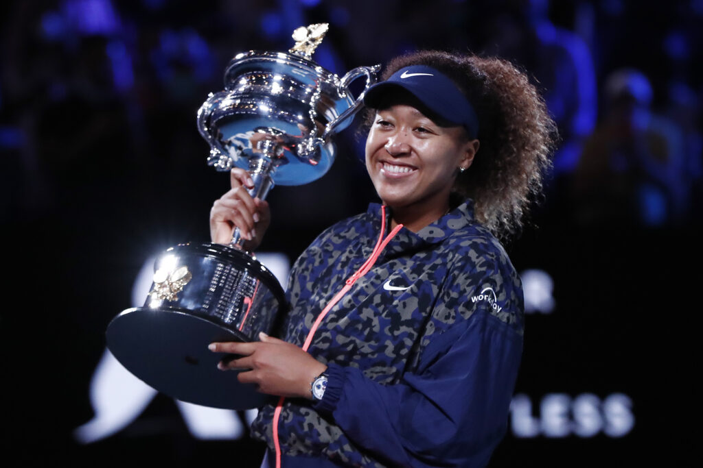 Naomi Osaka smiles while holding the 2021 Australian Open trophy
