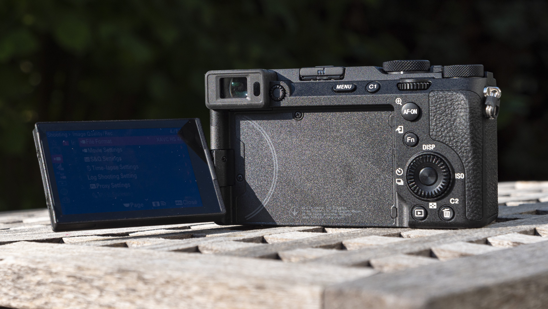 Touchscreen flipped out to the side of the Sony A7C R camera outside on a wooden table