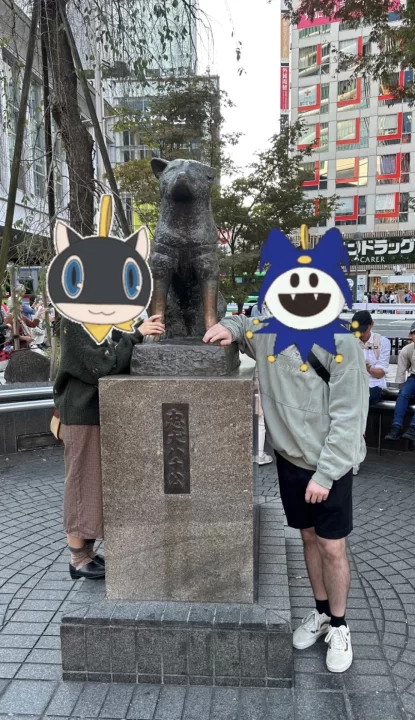Photo of two people posing in front of the famous Hachikō dog statue.