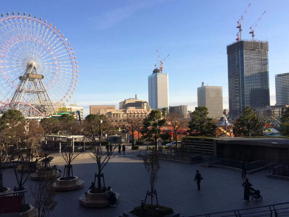 Photo of Minato Mirai in Yokohama. A large ferris wheel is seen amidst a skyline of tall buildings. 