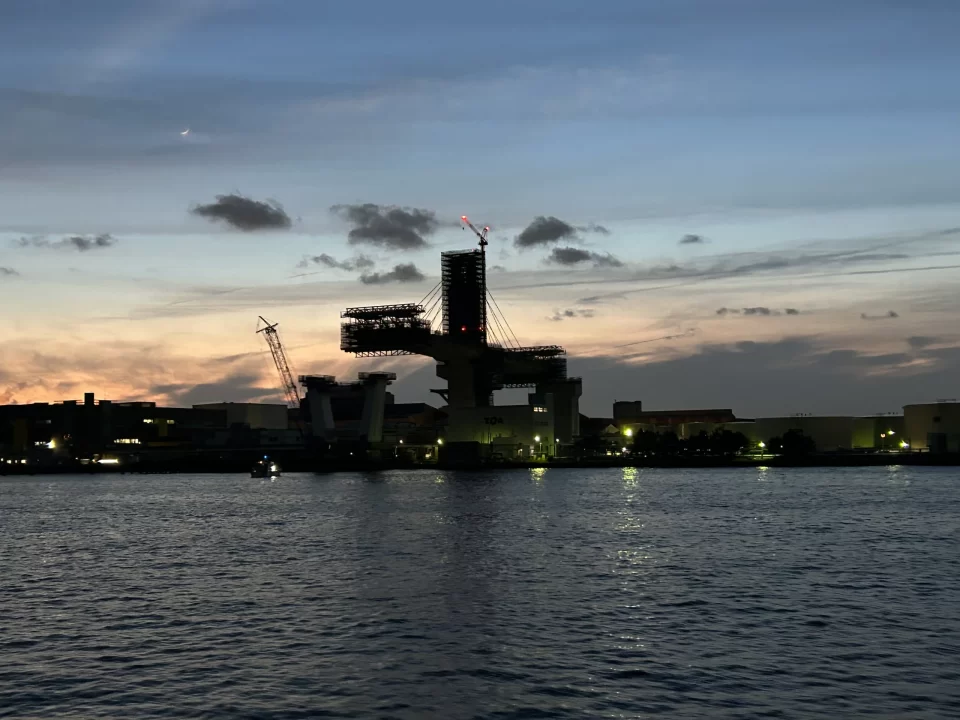 Photo of the Keihin Industrial Zone outside the port of Yokohama. A large suspension bridge can be seen mid-construction. 