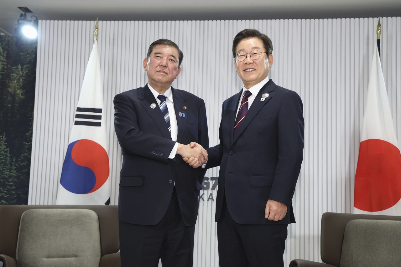 South Korean President Lee Jae Myung (right) shakes hands with Japanese Prime Minister Shigeru Ishiba ahead of their first in-person bilateral meeting on the sidelines of the G7, in Kananaskis, Alberta, on June 17, 2025. (Kyodo News via AP)