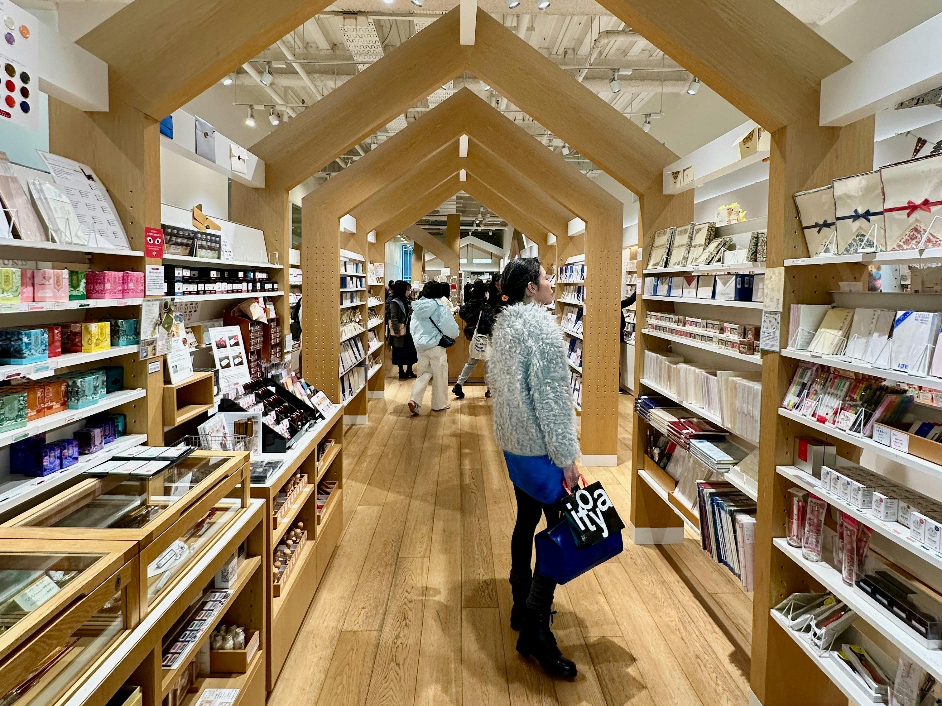 A shopper looking at a wall display of stationary in Tokyo.