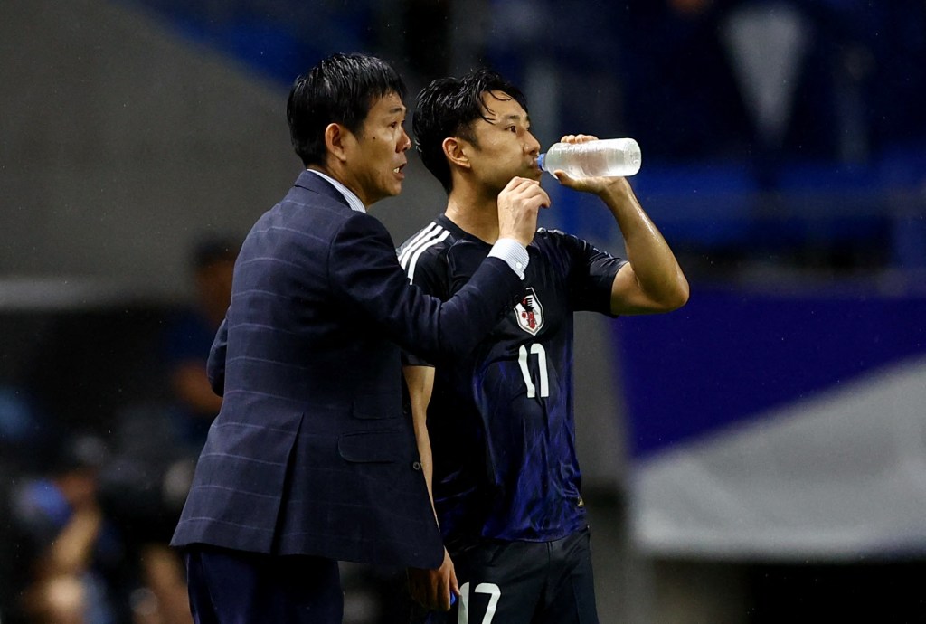 Japan's Hajime Moriyasu giving instructions to Ryoya Morishita.