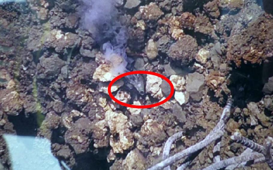 Smoke, circled in red, rises from a pile of rubble at a consruction site. 