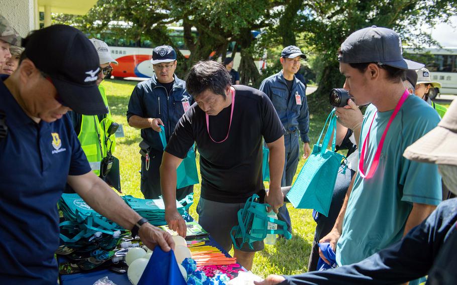 People look at merchandise on a table outdoors.