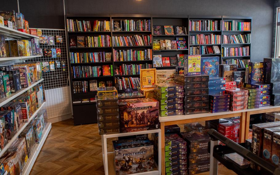 Bookstore shelves line a shop that holds many games, books and items.