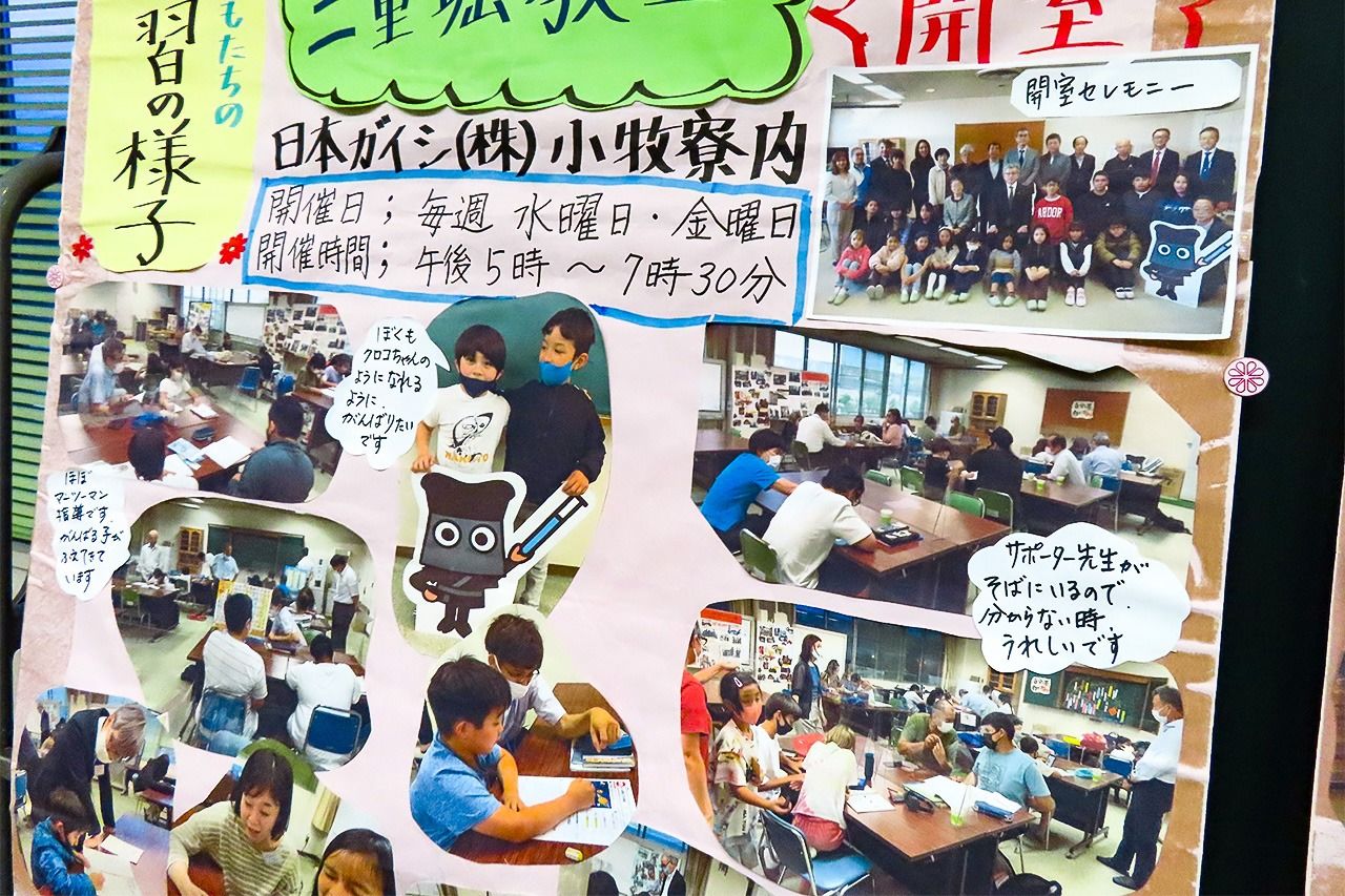 A display of photos of children studying and taking part in classroom events. (© Tanaka Keitarō)