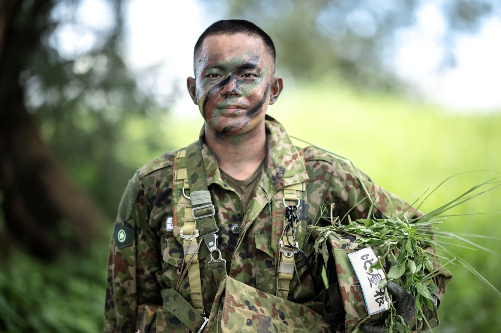 Takuma Hiyane, a newly-enlisted member of the Japan Ground Self-Defence Force (JGSDF), posing for a photograph following an exercise at JGSDF Camp Naha in Okinawa Prefecture June 9, 2025. — AFP pic
