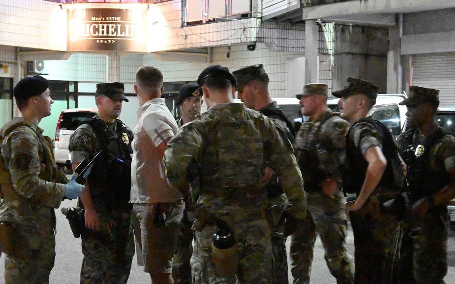 U.S. military police detain a service member during a joint patrol.