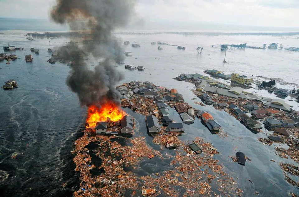 Houses are swept by water following a tsunami and earthquake in Natori City in northeastern Japan on March 11, 2011. REUTERS