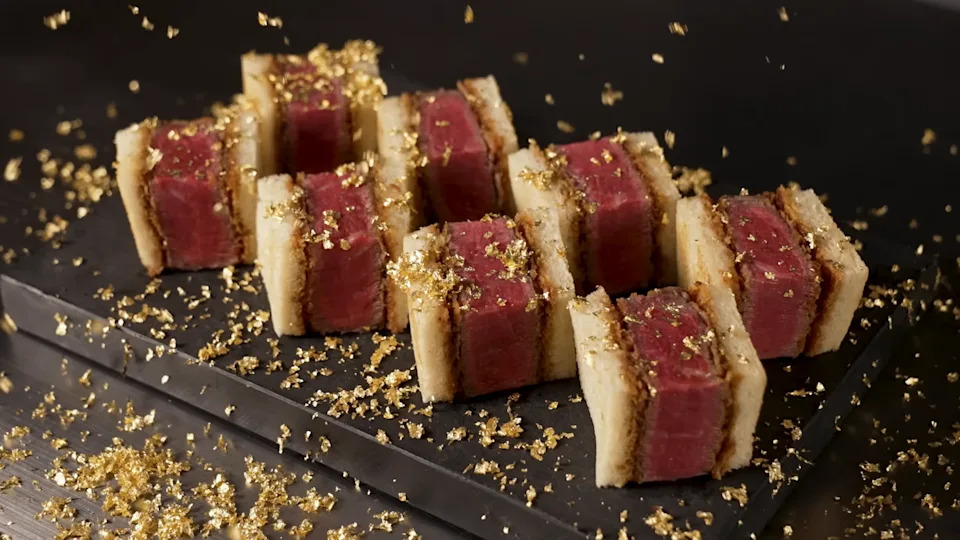 Sandwich bites made with wagyu meat topped with gold flecks.