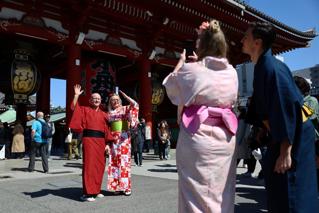 Russian tourists wearing traditional Japanese clothes pose for a photograph near Sensoji temple at Asakusa district, a popular sightseeing spot in Tokyo. Photo: Reuters