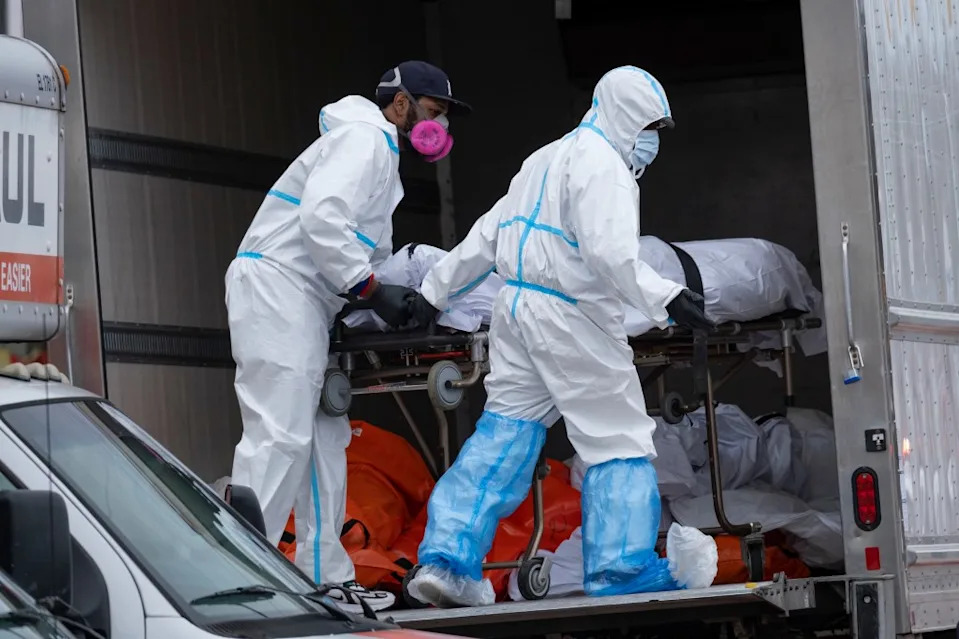 Pandemic workers move bodies to a refrigerated truck from the Andrew T. Cleckley Funeral Home in Brooklyn, New York, on April 29, 2020. AP