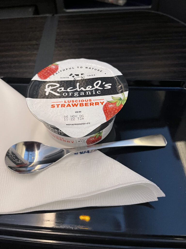 A container of yogurt and a spoon.