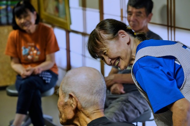 Yukiko Akuzawa, right, helps repeat a journalist's question with a bit louder voice by her father Kokichi Akuzawa, who was recently recognized by Guinness World Records as the oldest person to climb Mount Fuji (male), during an interview with The Associated Press as Motoe Hoshino, left, and Yuji Akuzawa, Yukiko's husband, listen in Maebashi, northeast of Tokyo, Wednesday, Sept. 3, 2025. (AP Photo/Hiro Komae)