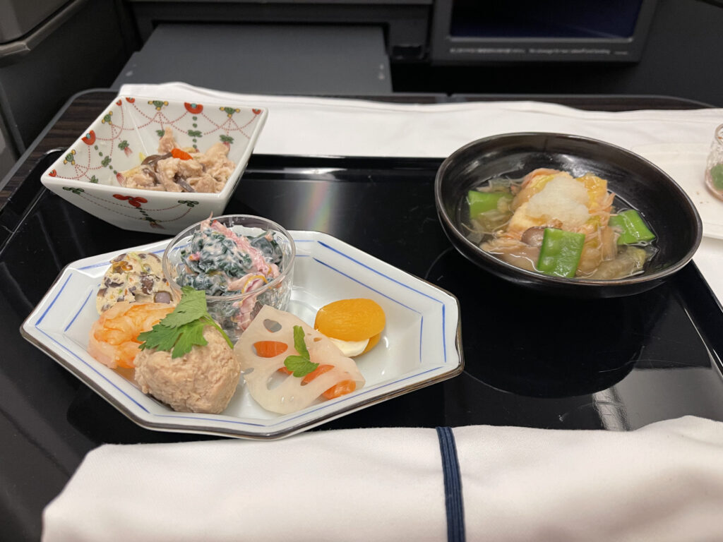 A starter course with multiple small plates is displayed attractively on the tray table.