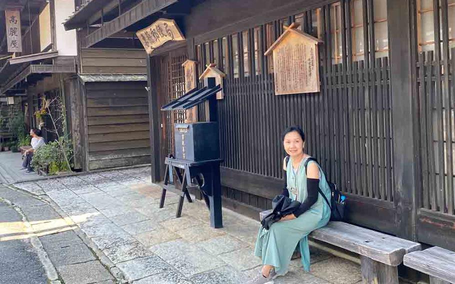author’s wife sitting on a bench in Tsumago