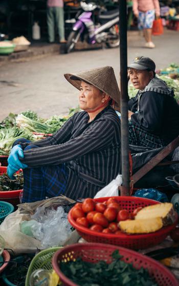 Two peddlers sell vegetables.