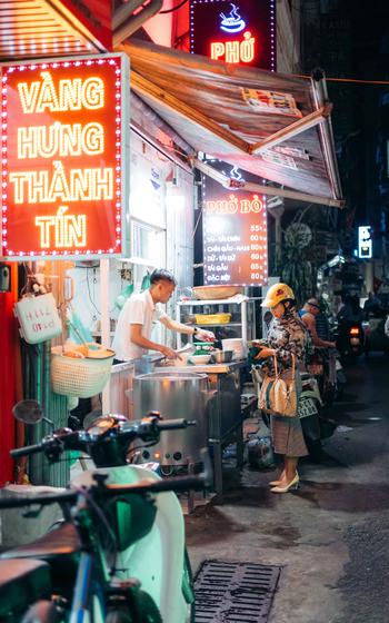 The interior of Pho Suong. A customer buys pho.