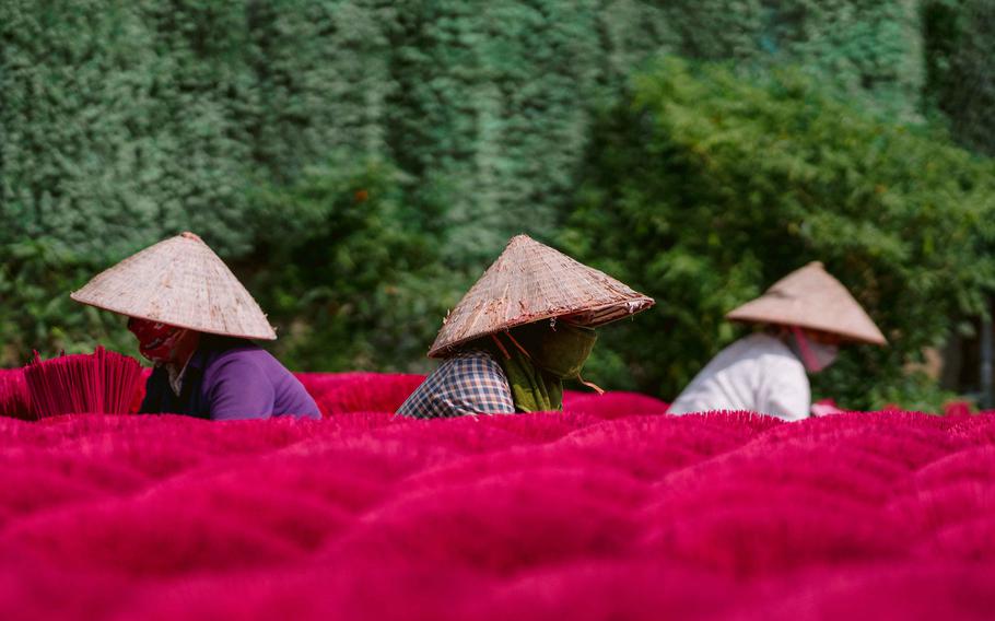Workers pile up incenses.