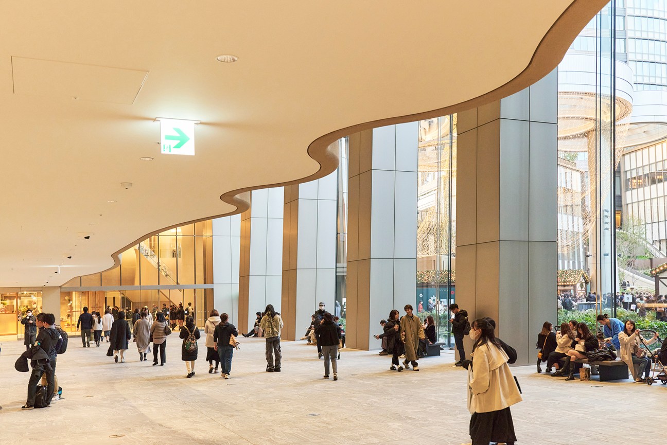 Spacious plaza with people walking beneath a large canopy structure
