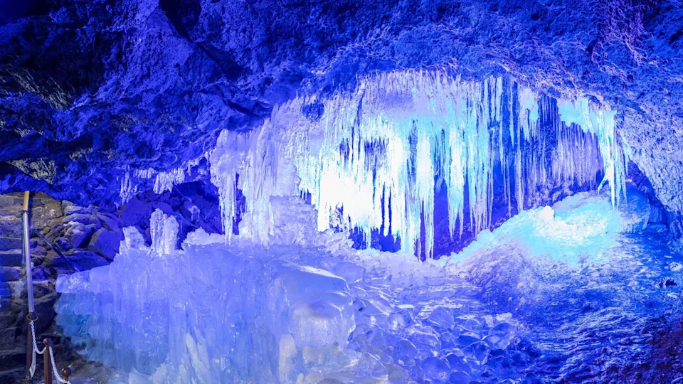  View of the inside of the Narusawa Ice Cave near Mount Fuji in Japan. The ceiling is low and covered in icicles. 